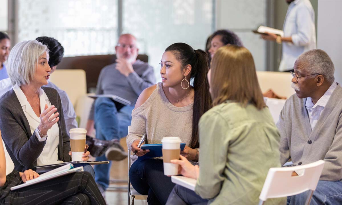 Group of People Sitting in Circle Discussing Plan of Action