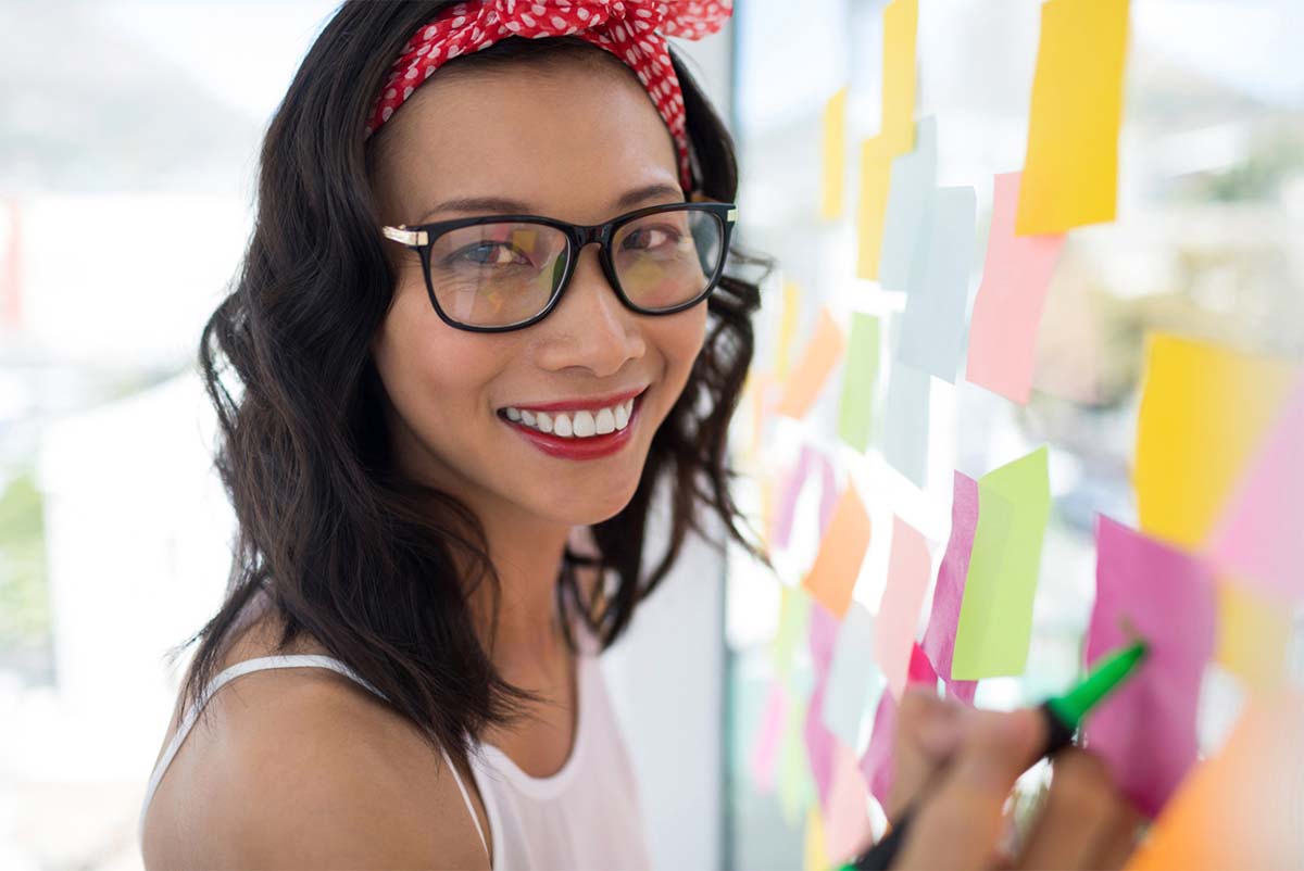 Woman with Red Hairband Writing Down Ideas on Sticky Notes